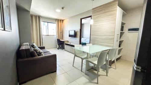 a living room with a table and a couch at Beach Class Convention - Flats em Boa Viagem por Yolo in Recife