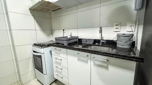 a small kitchen with a sink and a stove at Beach Class Convention - Flats em Boa Viagem por Yolo in Recife