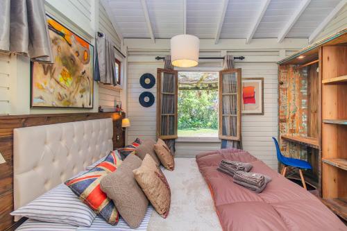 a bedroom with a bed with pillows on it at Vieja Hacienda in Praia do Rosa