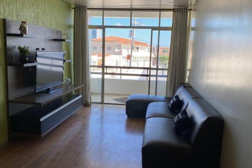 a living room with a couch and a large window at Ap da Auri in Petrolina