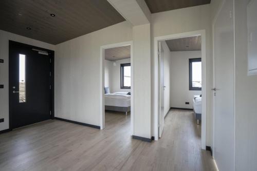 a room with white walls and a bedroom with a bed at Blue View Cabins in Reykholt