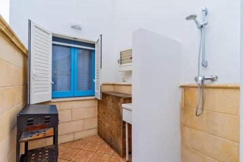 a kitchen with a stove and a window and a shower at Petracca home in Torre San Giovanni Ugento
