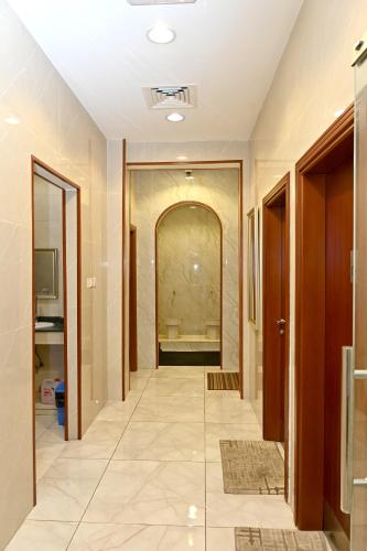a hallway with a tile floor and a hallway with a door at Durrat Alkhuwair Hotel Apartment درة الخوير للشقق الفندقية in Muscat