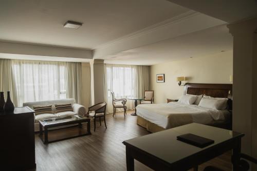 a hotel room with a bed and a living room at Hotel Almería in Salta