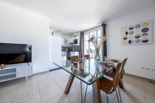 une salle à manger avec une table et des chaises en verre dans l'établissement S2 Disney Park, à Serris