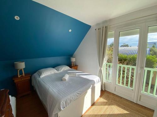 - une chambre bleue avec un lit et une grande fenêtre dans l'établissement Villa Mirabelle - Proche plage, à Merville-Franceville-Plage