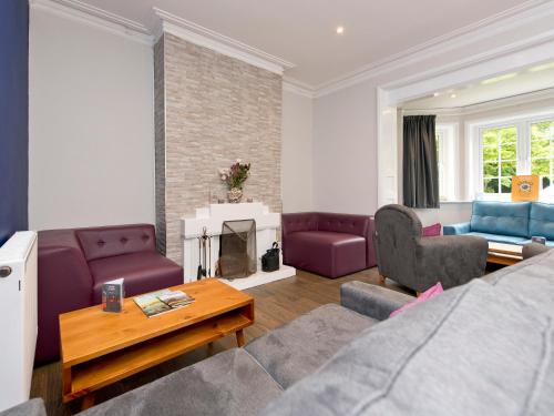 a living room with purple furniture and a fireplace at YHA New Forest in Burley