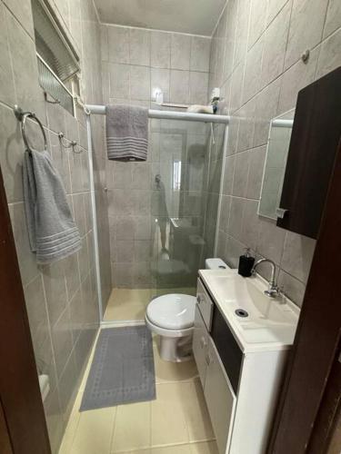 a bathroom with a shower and a toilet and a sink at Cantinho do Mané in Florianópolis