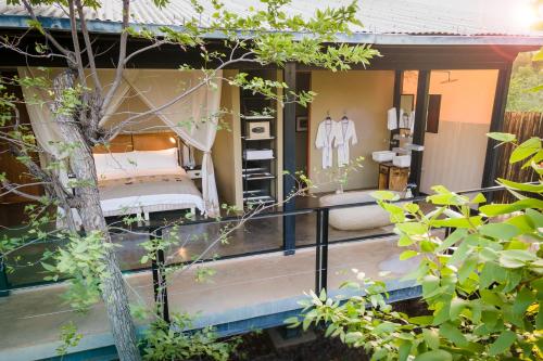 a room with two beds on a porch at The Outpost in Makuleke Contract Park