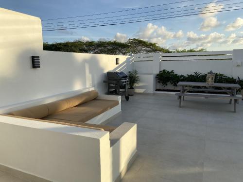 a balcony with a bench and a picnic table at Movida Inn Aruba in Palm-Eagle Beach