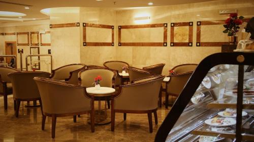 a restaurant with a table and chairs in a room at Nozol Royal Inn Hotel in Al Madinah