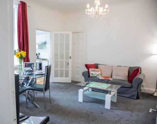a living room with a couch and a table at Glebe Street Apartment in Fife