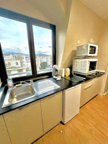 une cuisine avec évier et four micro-ondes ainsi qu'une fenêtre dans l'établissement Nice Centre, Magnifique Studio Proche Mer, à Nice