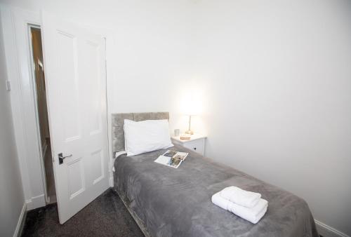 a bedroom with a bed with two towels on it at Glebe Street Apartment in Fife