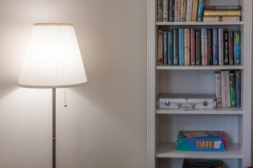 a lamp sitting next to a book shelf with books at Glebe Street Apartment in Fife