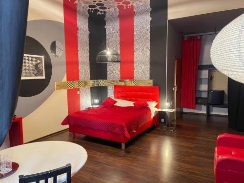 a red bedroom with a red bed and a table at Castle Inn in Warsaw