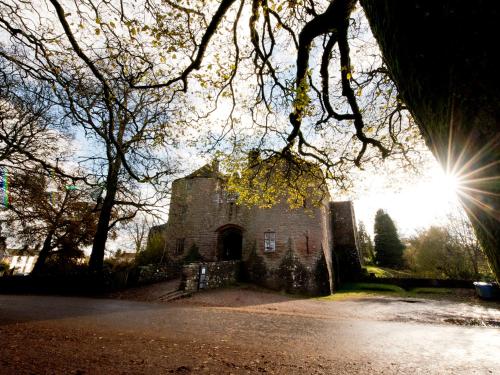an old stone building with the sun in the background at YHA St Briavels Castle in Saint Briavels