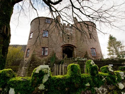 an old stone castle with a fence in front of it at YHA St Briavels Castle in Saint Briavels