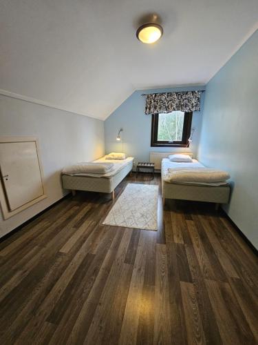 a room with two beds and a window at Romme stugby in Borlänge