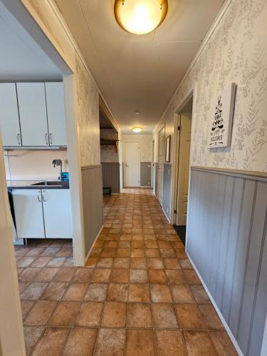 a hallway of an apartment with a kitchen and a floor at Romme stugby in Borlänge