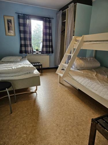 a bedroom with two bunk beds and a window at Romme stugby in Borlänge