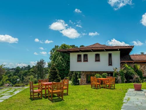 a patio with tables and chairs in front of a house at Mansão Nacional Inn in Campos do Jordão