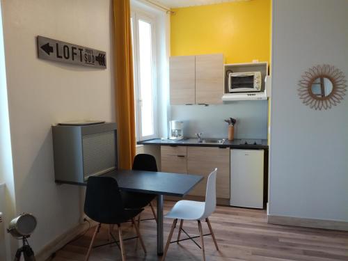 une cuisine avec une table et des chaises dans une pièce dans l'établissement SCI les THERMES 17, à Rochefort