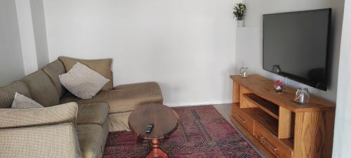 un soggiorno con divano e TV a schermo piatto di Seaview Self catering cottage a Sea View