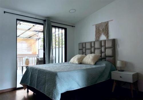 une chambre avec un lit et une grande fenêtre dans l'établissement Posada Botero, à San Andrés