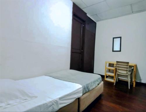 une chambre avec deux lits, une table et une chaise dans l'établissement Posada Botero, à San Andrés