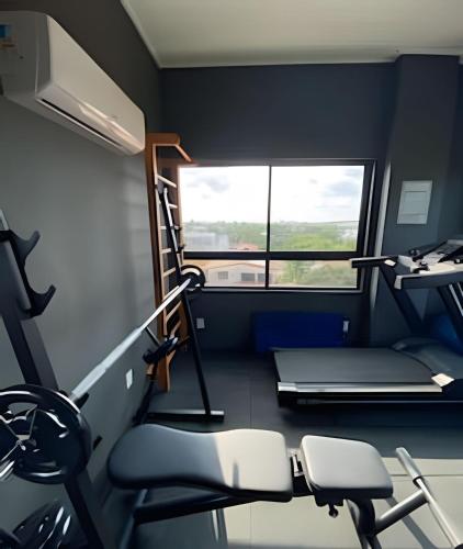a room with a gym with a treadmill and chairs at Flat pé na areia na praia de Porto de Galinhas próximo as piscinas naturais. in Porto De Galinhas