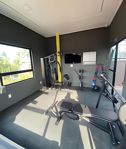 a gym with treadmills elliptical machines and a window at Flat pé na areia na praia de Porto de Galinhas próximo as piscinas naturais. in Porto De Galinhas