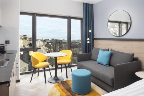 a living room with a couch and a table and chairs at Residence Inn by Marriott Cork in Cork