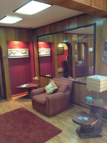 a living room with a couch and a large mirror at Hotel Le Mirage in Puerto Montt