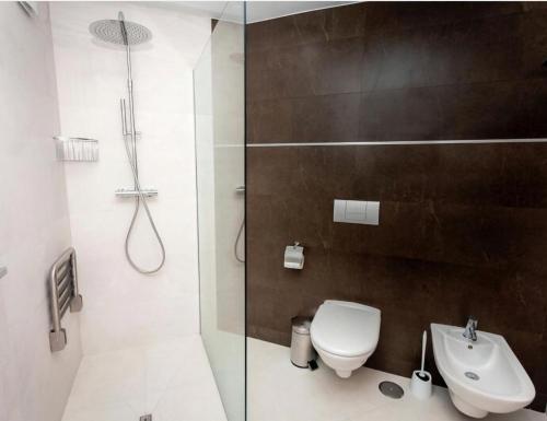 a bathroom with a shower and a toilet and a sink at Apartamento Marmara in Jávea