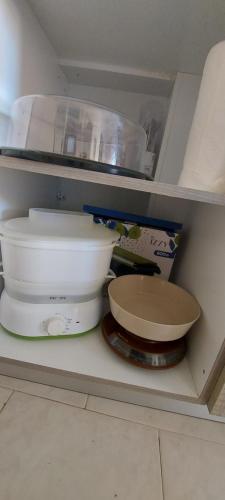 a shelf with bowls and other kitchen utensils at Nenita Home in Nénita