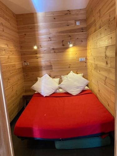 Cette petite chambre comprend un lit rouge dans une cabine. dans l'établissement SLA 203-Familial, 2 pièces pour 4pers, à Tignes