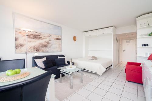 a living room with a couch and a bed at TimmenKoje App 290 in Timmendorfer Strand
