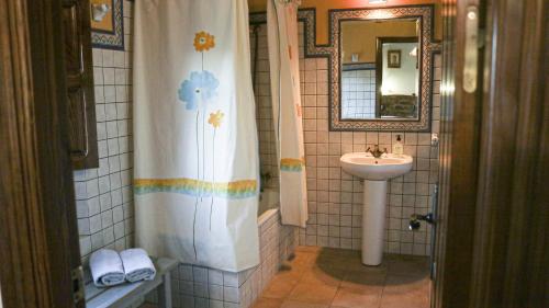 ein Badezimmer mit Waschbecken und Duschvorhang in der Unterkunft Finca Ecológica Morera in Aroche