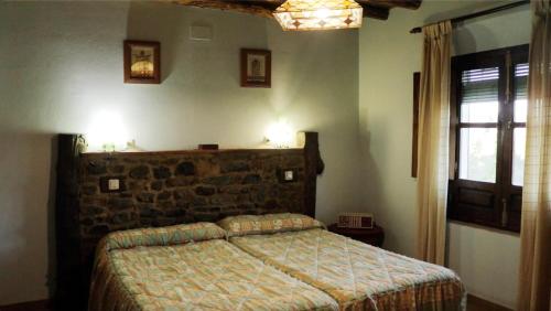 ein Schlafzimmer mit einem Bett und einer Ziegelwand in der Unterkunft Finca Ecológica Morera in Aroche