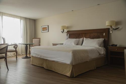 a hotel room with a large bed and a table at Hotel Almería in Salta