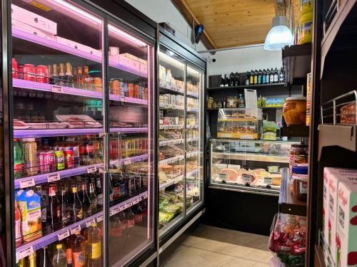 a grocery store refrigerator filled with lots of food and drinks at Hostel & Glamping Santa Fortunata in Sorrento
