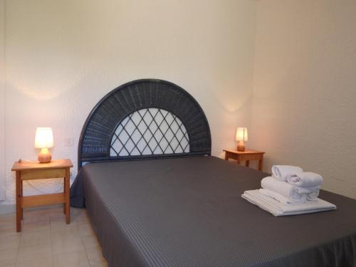 a bedroom with a bed with two lamps on two tables at Résidence les Hameaux de Bocca del Oro in Porto-Vecchio