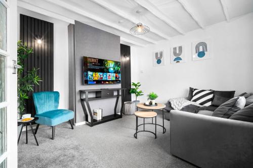 a living room with a couch and a tv at Three Bedroom House - Garden Space - Parking Included - Netflix Access - Parking - 74B in Walsall Wood