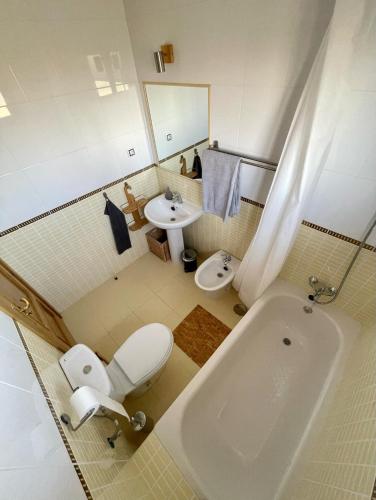 a bathroom with a toilet and a sink and a tub at Villa Maracuya in Lajares