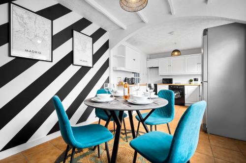 a dining room with a table and blue chairs at Three Bedroom House - Garden Space - Parking Included - Netflix Access - Parking - 74B in Walsall Wood