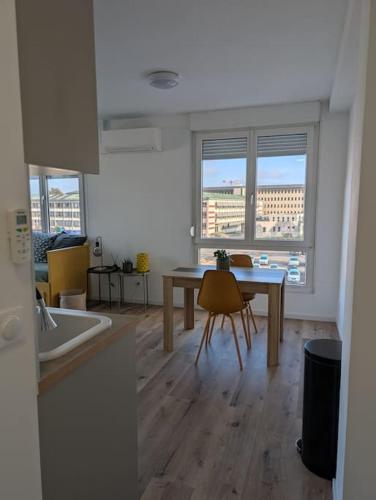 une cuisine avec une table et des chaises dans une pièce dans l'établissement Appartement moderne avec terrasse et vue panoramique, à Strasbourg