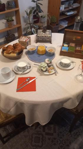 Una mesa con un mantel blanco con comida encima. en Relais de la Mothe LA SUITE, en Vrécourt