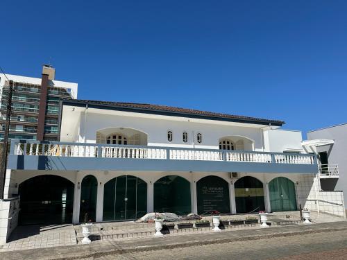 a white building with a balcony on top of it at Suíte Residencial320 - Timbó in Timbó