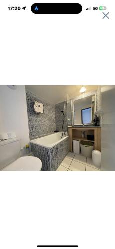 une salle de bain avec une baignoire, des toilettes et un lavabo dans l'établissement Duplex lumineux, à Saint-Jean-dʼOrbetiers